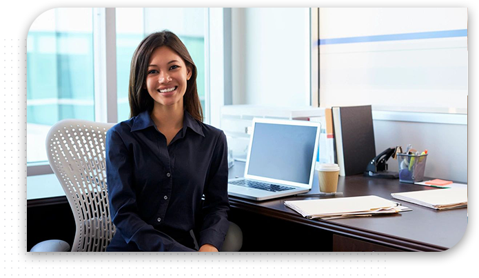 Portrait Of Female Doctor Sitting At Desk In Office